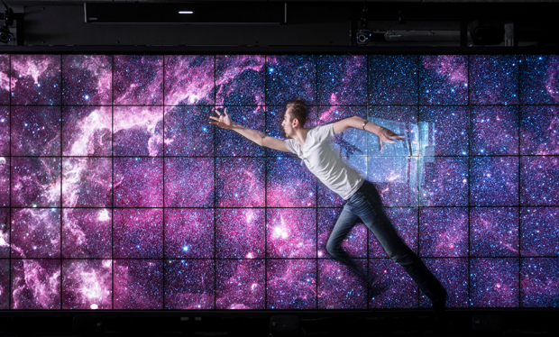 homme sur un écran représentant la galaxie