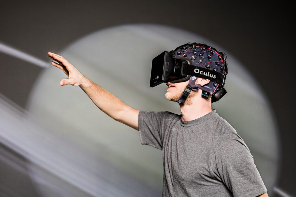 photo d'un homme qui porte un casque de VR et qui essaye de toucher quelque chose 