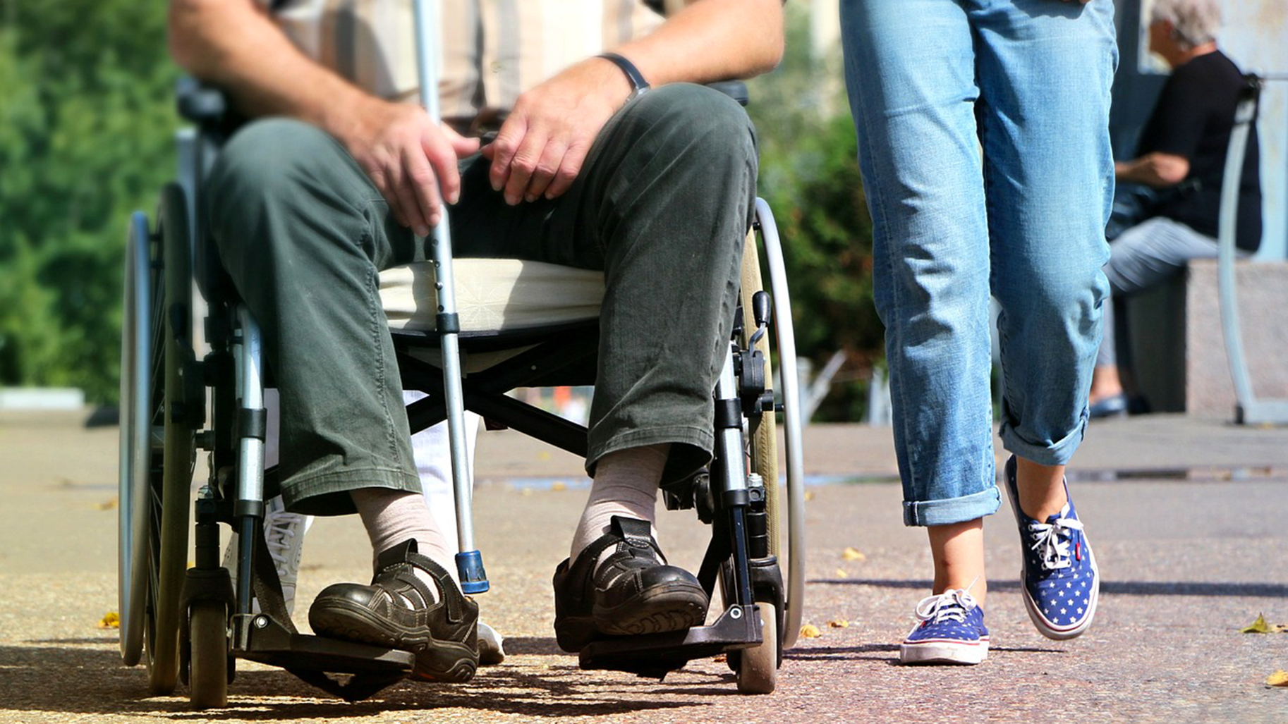 images d'une personne en fauteuil roulant qui tient une béquille, une personne marche à côté.