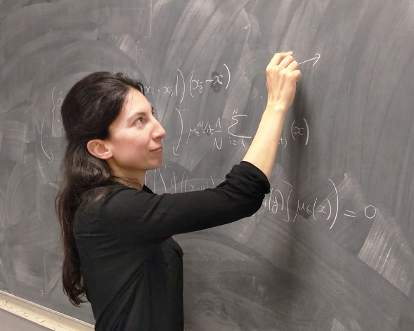 Photo de Nastassia Pouradier Duteil, chargée de recherche au sein de l’équipe-projet MAMBA, écrivant des formules sur un tableau noir.