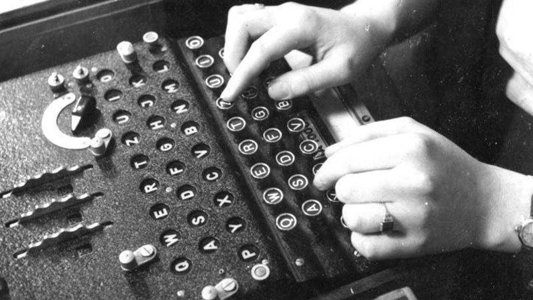 Photo en noir et blanc représentant la machine Enigma en cours d'utilisation.